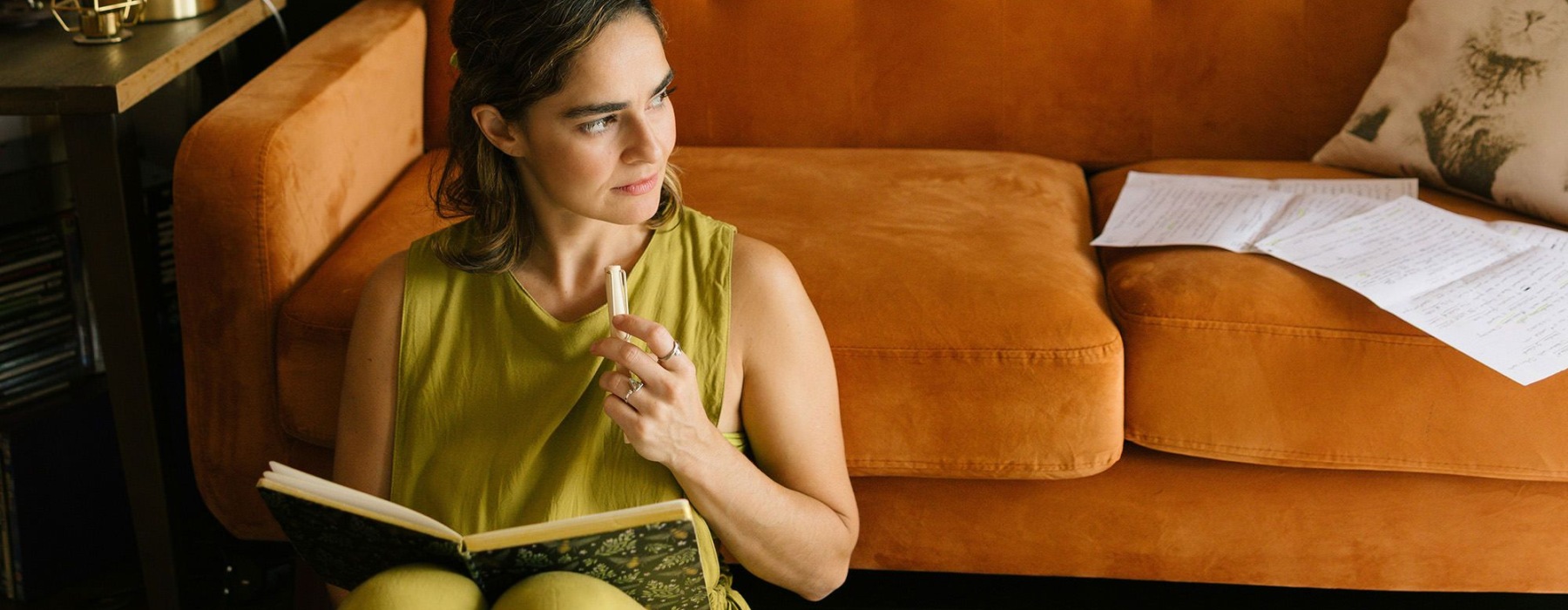 woman leaning on a couch reading a book
